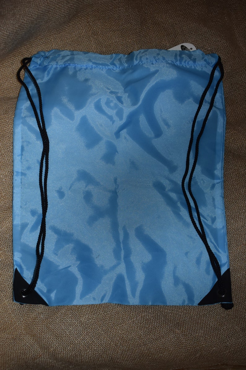 May include: A light blue drawstring bag with black drawstrings and black trim. The bag is made of a smooth, silky material.
