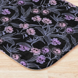 Pastel goth bath mat w/ floral skull design in blue, pink, purple, & black. A fun dark botanical accent to any spooky witch's bathroom decor