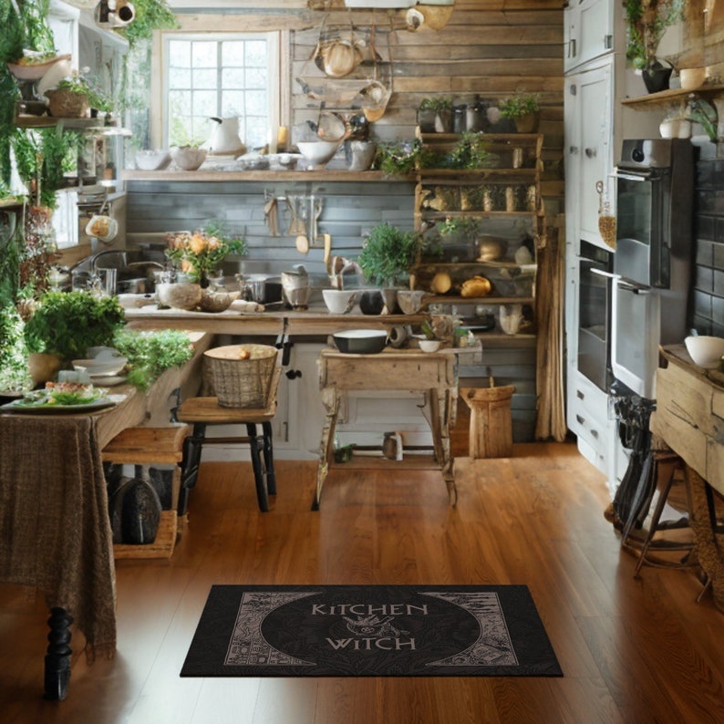 May include: A black kitchen rug with the text "Kitchen Witch" in a circle with a witch's silhouette inside. The rug is on a wooden floor in a rustic kitchen.