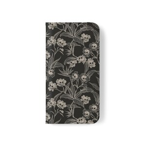 May include: Black phone case with a white floral pattern featuring skulls.