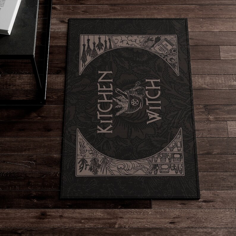 May include: Black and white kitchen rug with the text "Kitchen Witch" in a stylised font. The rug features a variety of illustrations, including herbs, a cauldron, and a crescent moon.
