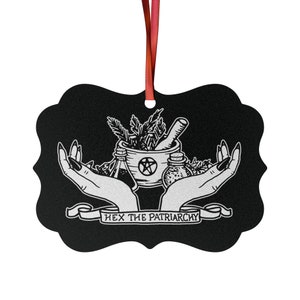 May include: Black and white illustration of two hands holding a mortar and pestle, herbs, and bottles. The text "Hex the Patriarchy" is written on a banner below the hands.