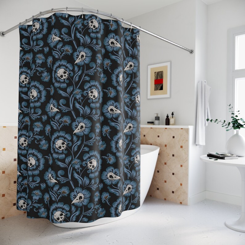 Puede incluir: Una cortina de ducha negra con un patr&oacute;n floral con flores azules y cr&aacute;neos de p&aacute;jaros blancos.