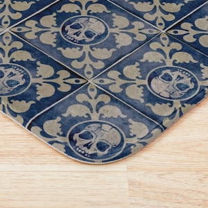 May include: Blue and beige patterned floor tile with a skull design. The tile has a distressed look and is made of ceramic.