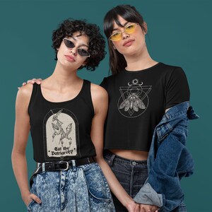 Może przedstawiać: Dwie osoby w czarnych tank topach i koszulkach z graficznymi wzorami. Tank top przedstawia czarno-białą ilustrację modliszki z tekstem "Eat the Patriarchy". Koszulka przedstawia czarno-białą ilustrację ćmy w geometrycznym wzorze.
