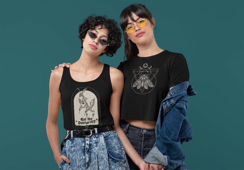 Może przedstawiać: Dwie osoby w czarnych tank topach i koszulkach z graficznymi wzorami. Tank top przedstawia czarno-białą ilustrację modliszki z tekstem "Eat the Patriarchy". Koszulka przedstawia czarno-białą ilustrację ćmy w geometrycznym wzorze.