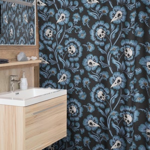 Puede incluir: Una cortina de ducha con fondo azul oscuro y un patr&oacute;n repetido de calaveras blancas y flores azules.