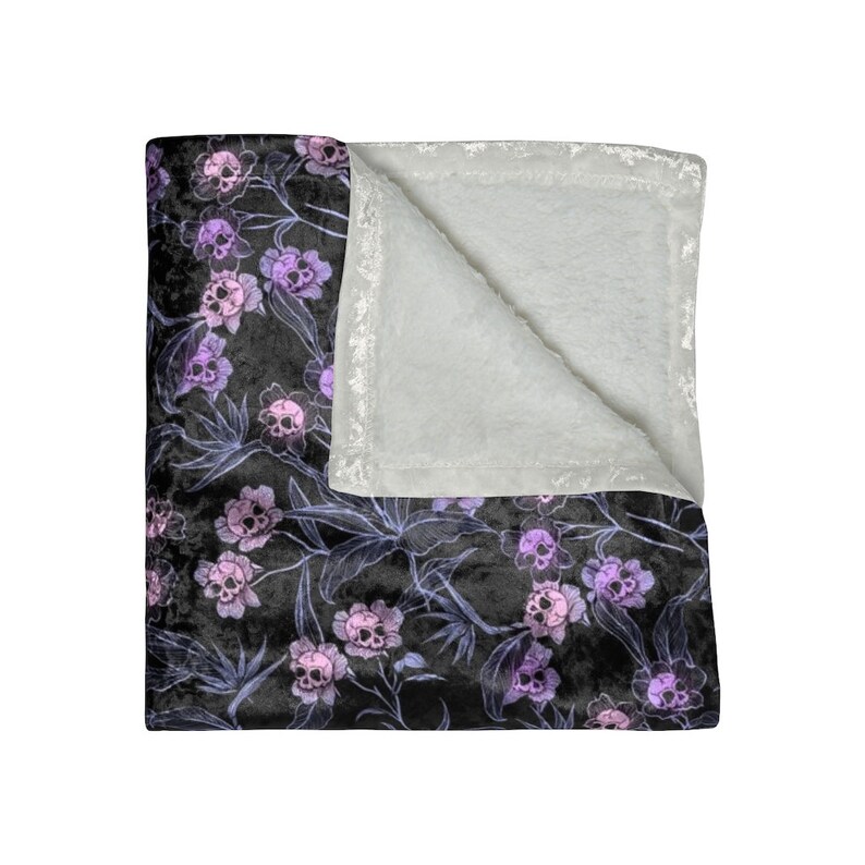 Crushed velvet blanket with purple skull flowers and grey interior.