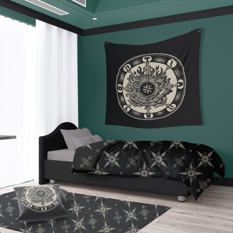 May include: A black and white tapestry with a circular design featuring a compass and symbols. The tapestry is hanging on a dark green wall above a black bed with a black and white patterned duvet cover.