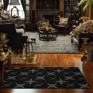 May include: Black and white patterned area rug with a geometric design. The rug is laid out on a hardwood floor in a living room setting.
