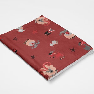 May include: Red fleece throw blanket with a repeating pattern of gray and red goats, pentagrams, and horns.