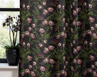 Op de afbeelding: Zwart gordijn met een bloemenpatroon. De bloemen hebben schedelvormige centra in roze en wit, met groene bladeren en stelen. De achtergrond is zwart.
