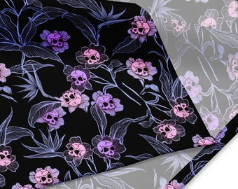 May include: A black fabric with a repeating pattern of white flowers with pink and purple skulls. The fabric is folded over itself, revealing a white background with a faint outline of the pattern.
