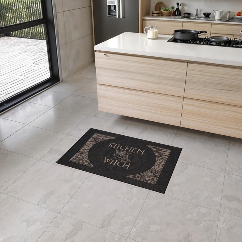 May include: A black kitchen rug with a decorative design and the text "Kitchen Witch" in a gold font.