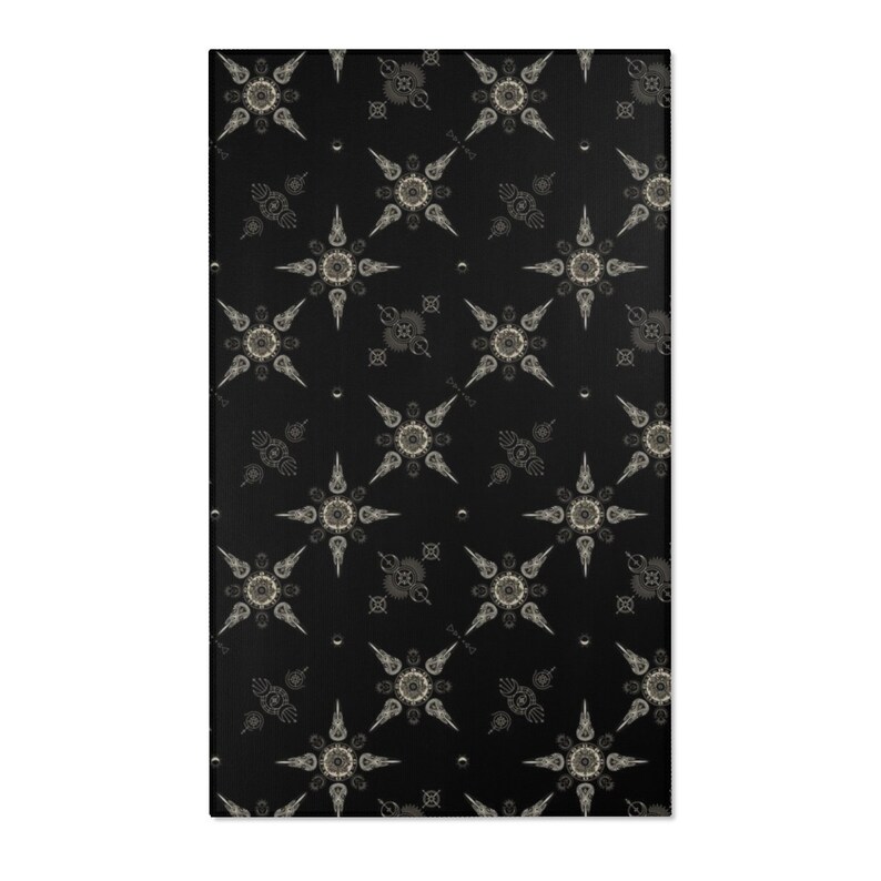 May include: Black and white patterned rug with a repeating design of stylized stars with a circular center. The rug has a subtle texture.
