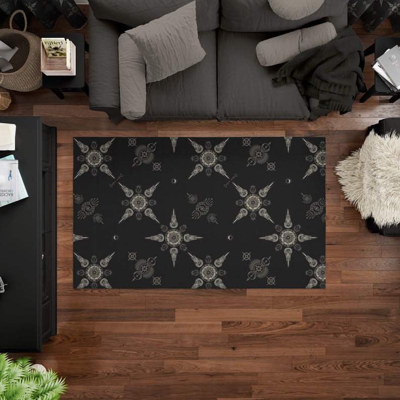 May include: Black and white area rug with a geometric pattern of stars and circles. The rug has a subtle sheen and is made of a soft, plush material.