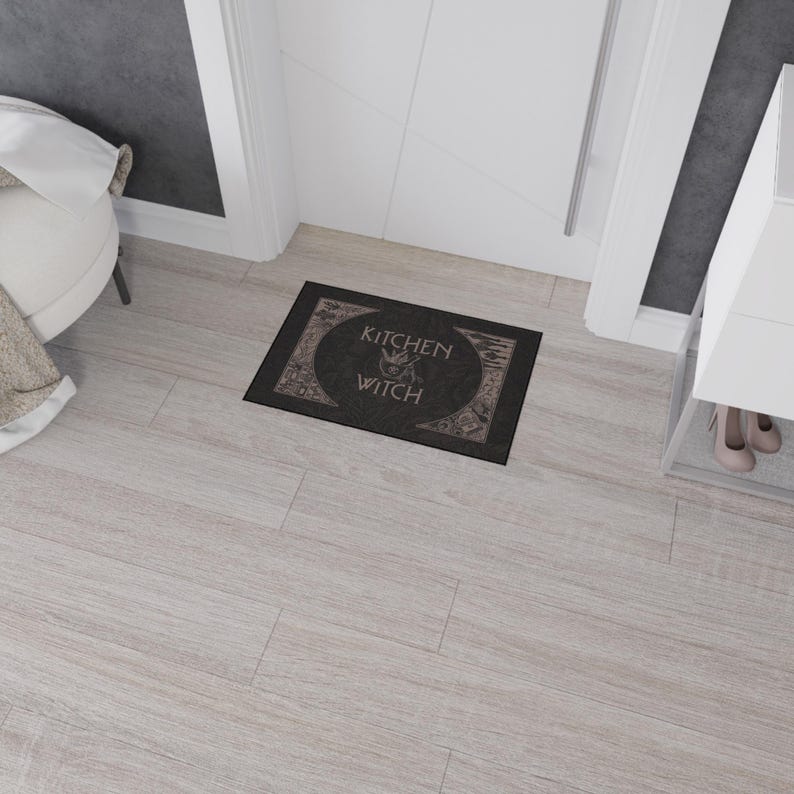 May include: Black doormat with the text "Kitchen Witch" in a white font. The text is surrounded by a circle with a witch's silhouette inside.