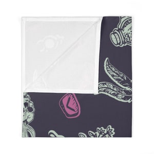 May include: A dark purple fabric with a repeating pattern of green and pink illustrations. The illustrations include a skull, a feather, a crystal, and a bottle.