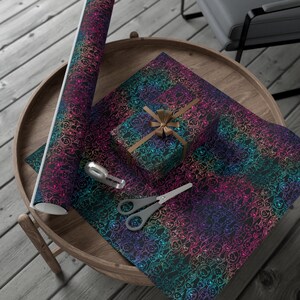 K&ouml;nnte beinhalten: Regenbogenfarbenes Geschenkpapier mit schwarzem Hintergrund und einem sich wiederholenden Muster aus kleinen wei&szlig;en Hundesilhouetten. Eine kleine Geschenkbox, die in das gleiche Papier eingewickelt ist, ist mit einem braunen Band gezeigt. Eine Rolle Geschenkpapier ist ebenfalls abgebildet.