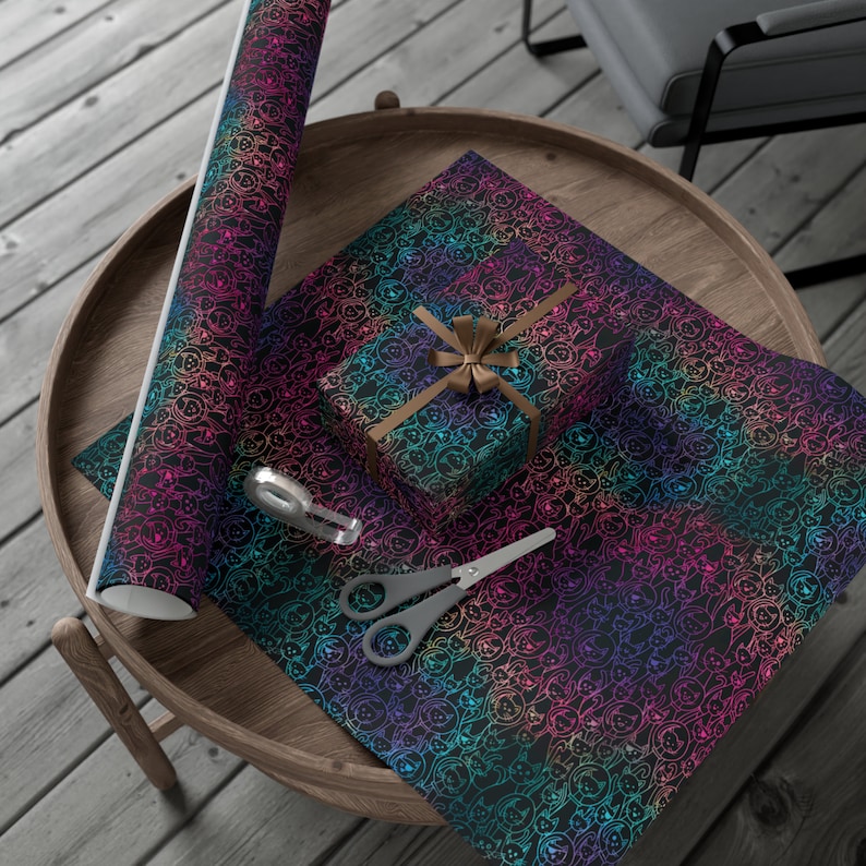 K&ouml;nnte beinhalten: Regenbogenfarbenes Geschenkpapier mit schwarzem Hintergrund und einem sich wiederholenden Muster aus kleinen wei&szlig;en Hundesilhouetten. Eine kleine Geschenkbox, die in das gleiche Papier eingewickelt ist, ist mit einem braunen Band gezeigt. Eine Rolle Geschenkpapier ist ebenfalls abgebildet.