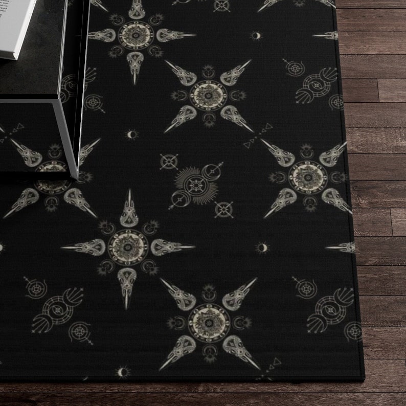 May include: Black and white rug with a repeating pattern of stylized stars with geometric details. The stars are made up of pointed shapes and circles.