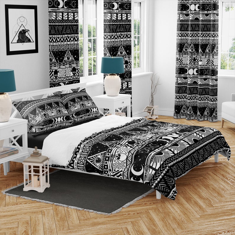 May include: Black and white duvet cover with a geometric pattern featuring moons, stars, eyes, and other mystical symbols. The duvet cover is on a bed with two matching pillowcases.