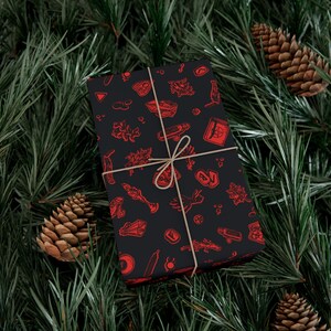 May include: A black gift box with a red and white pattern of various occult symbols, wrapped with twine and tied in a bow.