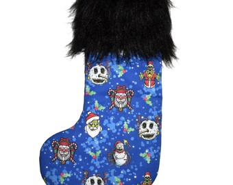 Puede incluir: Una media de Navidad azul con un puño de piel sintética negra. La media presenta un patrón repetido de varios personajes de la película Pesadilla antes de Navidad, incluidos Jack Skellington, Sally y Oogie Boogie.