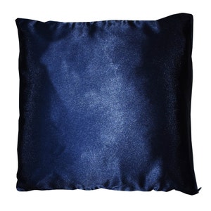 May include: A dark blue throw pillow with a subtle ombre effect. The pillow is made of a soft, velvety fabric.