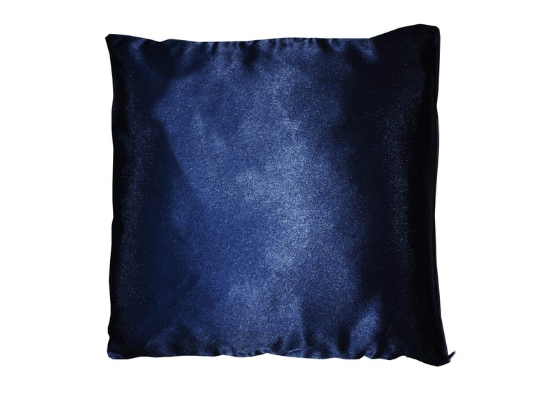 May include: A dark blue throw pillow with a subtle ombre effect. The pillow is made of a soft, velvety fabric.