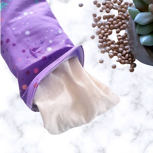 May include: A purple fabric pouch with a white lining and a star pattern. The pouch is partially open, revealing the white lining.