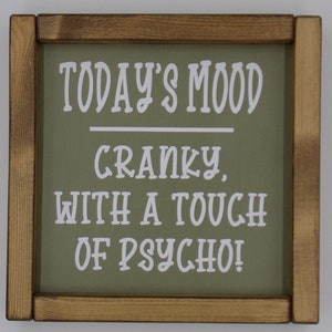 May include: A wooden sign with a green background and white text that reads "Today's Mood Cranky With A Touch Of Psycho!"