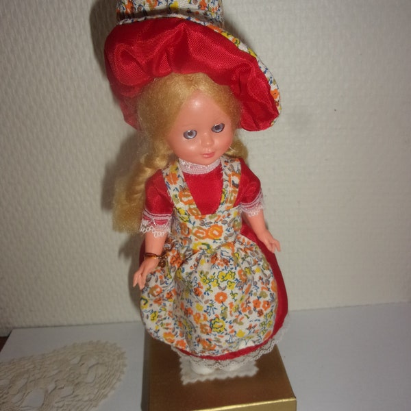 Small vintage doll placed on a candy box, 70s doll, candy box