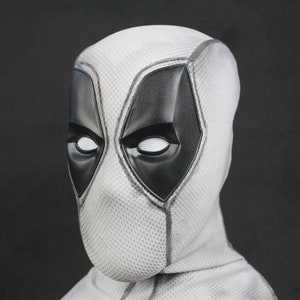 May include: A white Deadpool mask with black eye holes and a black mouth. The mask has a textured surface.
