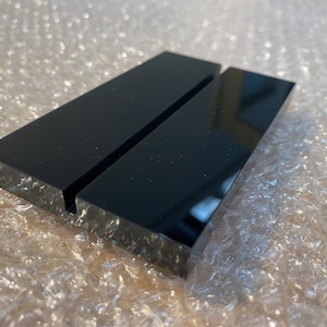 May include: Black acrylic display stand with two slots for holding business cards or other small items.