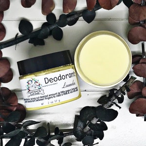 Könnte beinhalten: Ein weißes Glas mit schwarzem Deckel und einem gelben Etikett mit der Aufschrift "Deodorant Lavendel" und "Harmony Bath Goods". Das Glas ist mit einem gelben Deodorant gefüllt und steht auf einer weißen Oberfläche mit braunen Blättern.