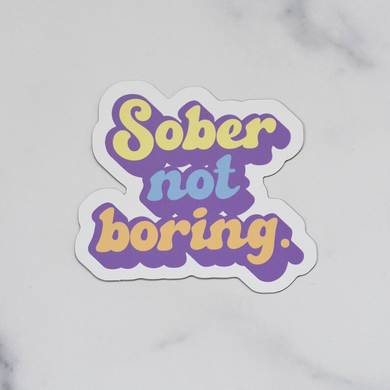 Magnet with "Sober not boring." printed on it. It is printed in pastel tones of purple, yellow blue and orange!