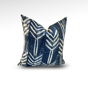 May include: Square decorative pillow with a dark blue and white geometric pattern. The pillow features a repeating design of vertical lines and arrow-like shapes. The fabric has a textured appearance, and the pillow is placed against a white background.