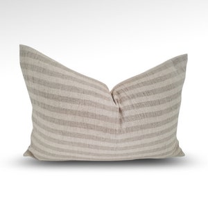 May include: A beige and white striped linen pillow with a rectangular shape.