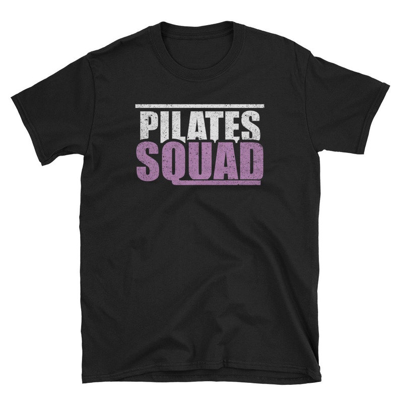 May include: Black t-shirt with the text "PILATES SQUAD" in white and purple lettering.