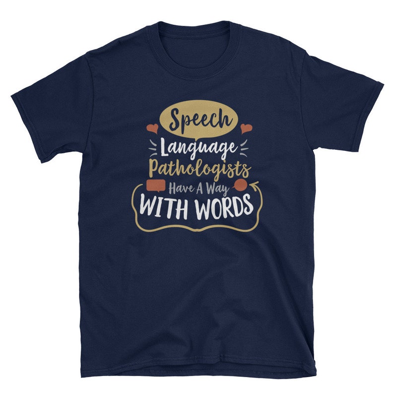 May include: Navy blue t-shirt with a white graphic that says "Speech Language Pathologists Have A Way With Words". The graphic includes a speech bubble, hearts, and a curved arrow.