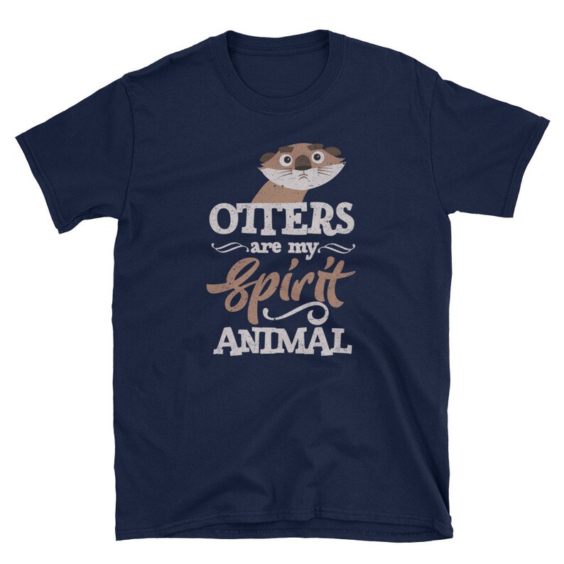 May include: Navy blue t-shirt featuring a cartoon otter illustration with the text "Otters are my spirit animal" in white and brown. The shirt is made of a soft material and is suitable for casual wear.
