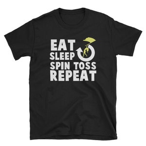 May include: Black t-shirt with white text that reads "Eat Sleep Spin Toss Repeat". A yellow silhouette of a person doing a spin toss is in the middle of the text.