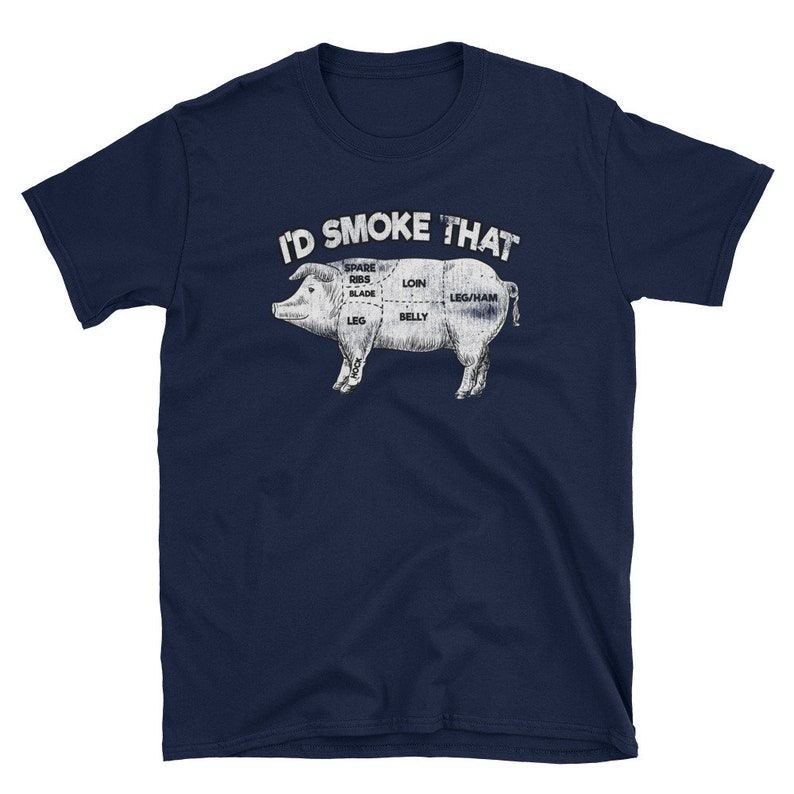 Puede incluir: Una camiseta azul marino con un gr&aacute;fico blanco de un cerdo con diferentes cortes de carne etiquetados. El texto "I'D SMOKE THAT" est&aacute; por encima del cerdo.