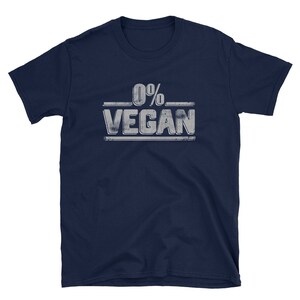 Pu&ograve; includere: Una t-shirt blu navy con una grafica bianca invecchiata che dice "0% VEGAN".