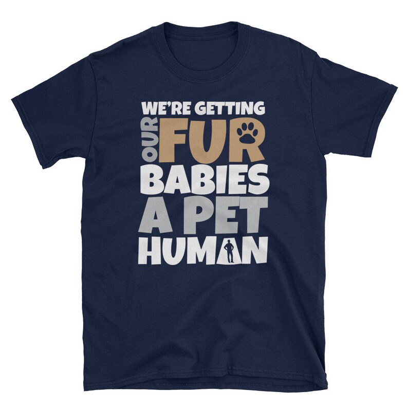 Puede incluir: Camiseta azul marino con texto blanco que dice "We're getting our fur babies a pet human". El texto est&aacute; en negrita, en una fuente de letra divertida. Una huella de pata est&aacute; incluida en el texto.