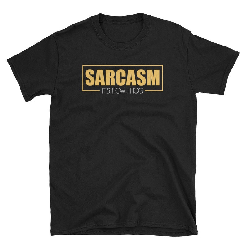 May include: Black t-shirt with a gold rectangle that says "SARCASM - IT'S HOW I HUG"