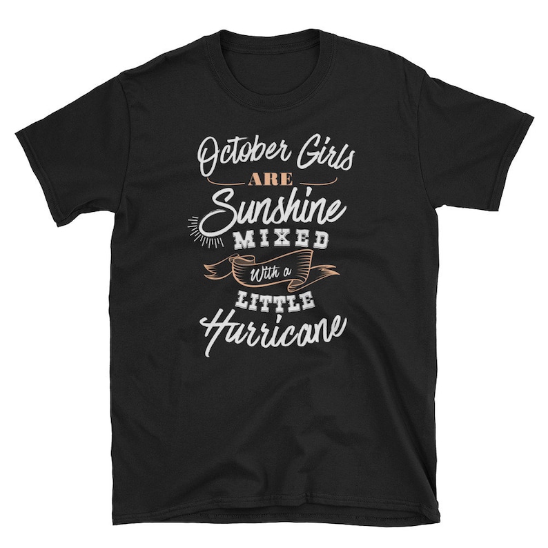 May include: Black t-shirt with the text "October Girls are Sunshine Mixed with a Little Hurricane" in white and peach lettering. The shirt is a short-sleeved crew neck.