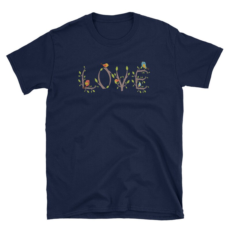 Pu&ograve; includere: Maglietta blu navy con una grafica della parola "LOVE" formata da rami con uccelli appollaiati su di essi. Gli uccelli sono rossi, gialli, blu e verdi.