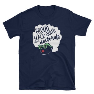 May include: Navy blue t-shirt with a white silhouette of a Black woman wearing green sunglasses and the text "Proud Black Queen with a doctorate" in white.
